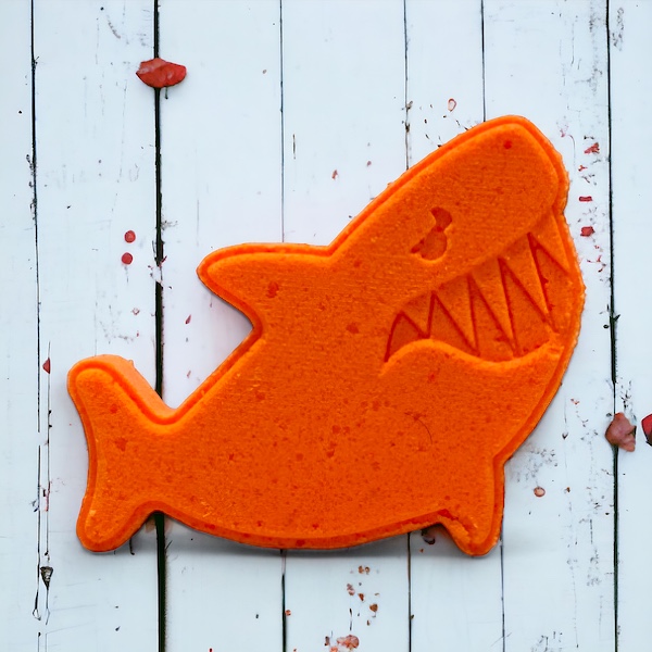 Shark fish bath bomb orange on a wooded background. At calla Lily all natural cocoa butter coconut oil non toxic kid friendly