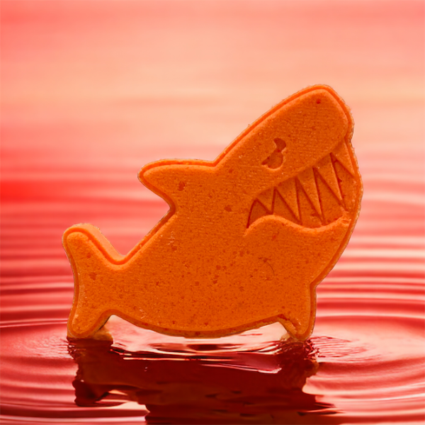 Shark fish bath bomb orange in a pool of water. At calla Lily all natural cocoa butter coconut oil non toxic kid friendly